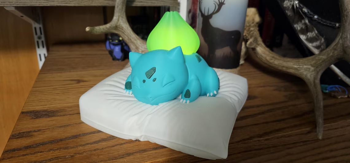Sleeping Bulbasaur on a pillow night light with glowing bulb